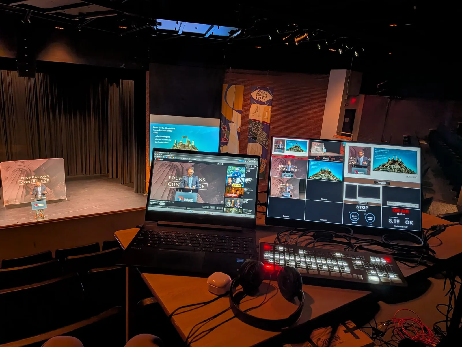 The streaming desk: switcher, multiview and the live YouTube page, with the stage behind